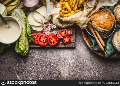 Tasty ingredients for chicken burger on rustic background , top view, border