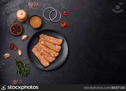 Tasty meat brawn or roll on a wooden cutting board with spices and herbs on a dark concrete background. Tasty meat brawn or roll on a wooden cutting board with spices and herbs