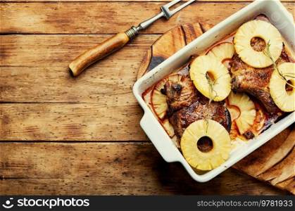 Tasty meat chop prepared with pineapple rings on old wooden table. Copy space. Meat steak with pineapple, space for text