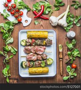 Tasty meat, vegetables and corn skewers in herbs marinate with fresh seasoning and Basting Brush for grill on rustic kitchen table background , top view