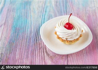 Tasty mini cake. Tasty mini cake with cherry on a color gradient background