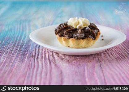 Tasty mini cake. Tasty mini cake with chocolate on a color gradient background