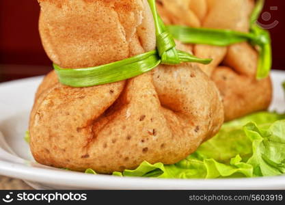 tasty pancakes stuffed with meat served with lettuce and green onion