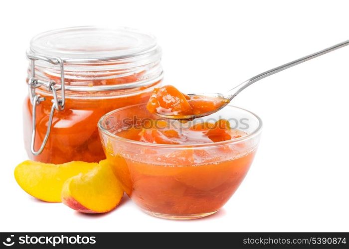 Tasty peach jam in glass jar with fruits over white