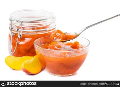 Tasty peach jam in glass jar with fruits over white