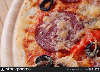 Tasty pizza on wooden plate close up