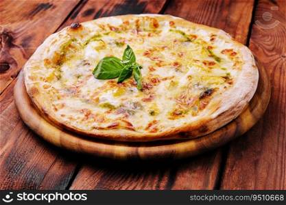 Tasty pizza with pesto sauce on wooden background