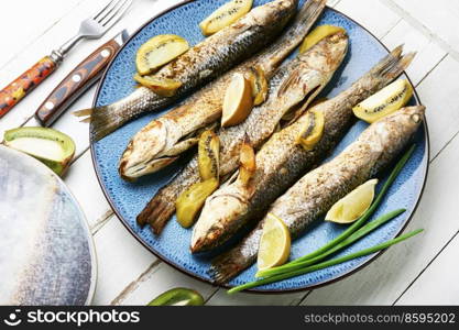 Tasty roast pelengas, appetizing fish with kiwi and lime.. Pelengas fried with lime and kiwi.