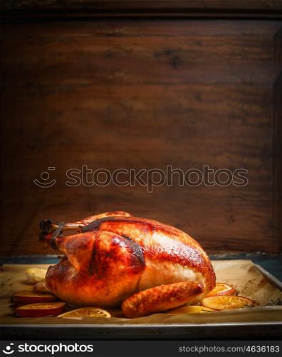 Tasty roasted turkey or chicken over wooden background, side view