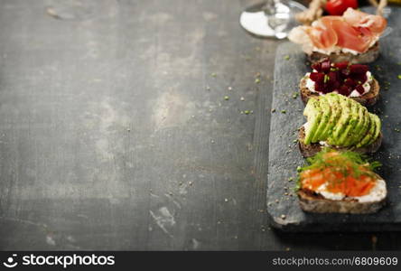 Tasty rye bread sandwiches withsalmon, avocado, beetroot, creamcheese, ham, herbs and spices