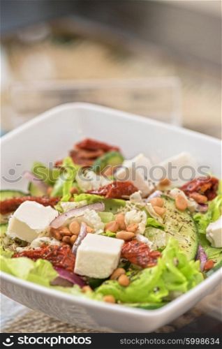 tasty salad closeup. Salad feta cheese lettuce sausage cucumbers and pine nuts