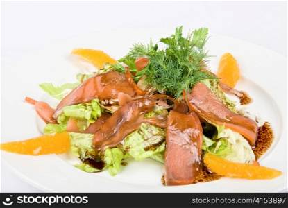 Tasty salad dish close up with fish and oranges on a white background