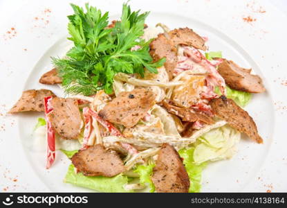 Tasty salad of meat and vegetable dish close up on a white background