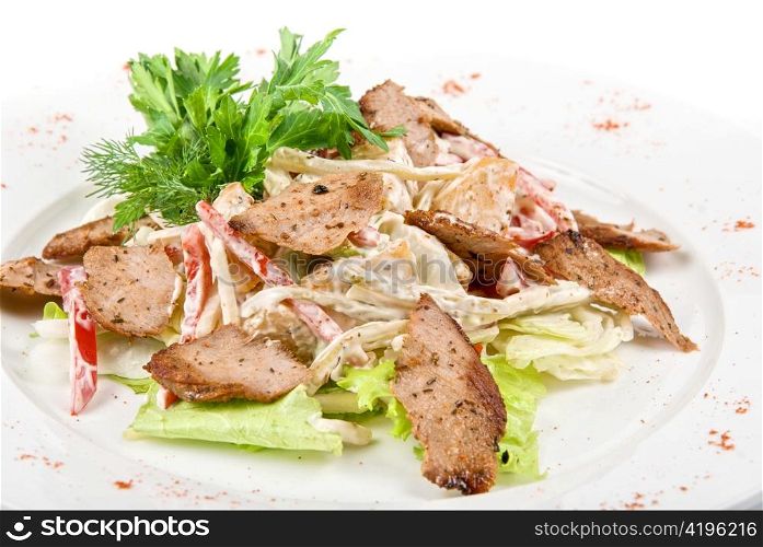 Tasty salad of meat and vegetable dish close up on a white background