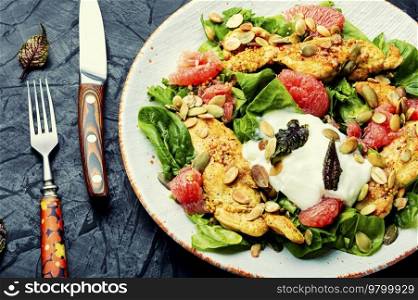 Tasty salad with chicken meat, herbs and grapefruit. Diet food. Spicy salad with chicken breast, greens and fruits