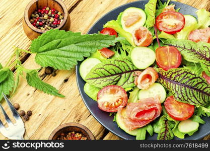 Tasty salad with trout,cherry tomato,cucumber and herbs. Vegetable salad with salmon