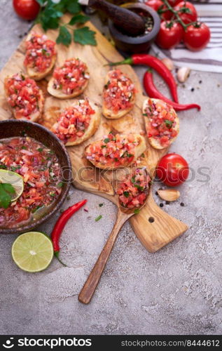 tasty salsa bruschetta snacks at domestic kitchen on wooden cutting board.. tasty salsa bruschetta snacks at domestic kitchen on wooden cutting board