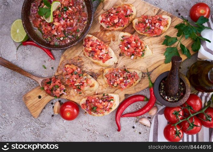 tasty salsa bruschetta snacks at domestic kitchen on wooden cutting board.. tasty salsa bruschetta snacks at domestic kitchen on wooden cutting board