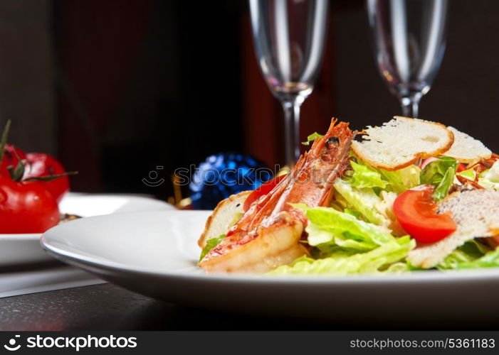 Tasty shrimp salad with vegetables on christmas table