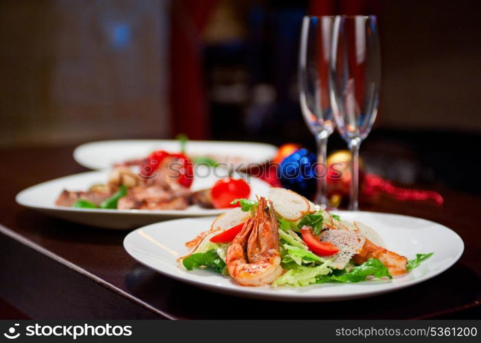 Tasty shrimp salad with vegetables on christmas table