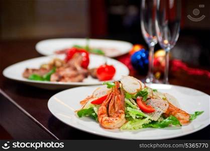 Tasty shrimp salad with vegetables on christmas table