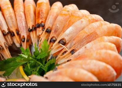 tasty shrimps with lemon and greens closeup