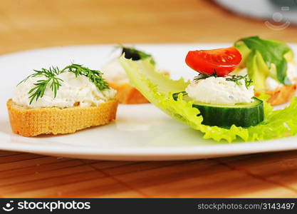 Tasty small sandwich from vegetables and cheese on dish