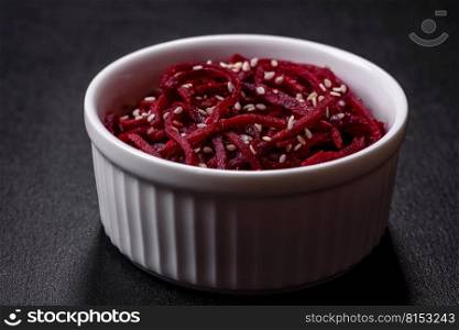 Tasty spicy Korean beet with spices and herbs on a dark concrete background. Asian food. Tasty spicy Korean beet with spices and herbs