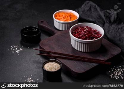 Tasty spicy Korean beet with spices and herbs on a dark concrete background. Asian food. Tasty spicy Korean beet with spices and herbs