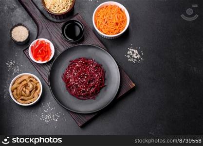 Tasty spicy Korean beet with spices and herbs on a dark concrete background. Asian food. Tasty spicy Korean beet with spices and herbs on a dark concrete background