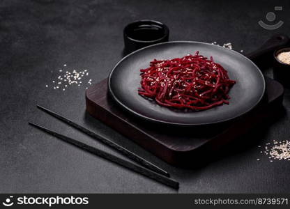 Tasty spicy Korean beet with spices and herbs on a dark concrete background. Asian food. Tasty spicy Korean beet with spices and herbs on a dark concrete background