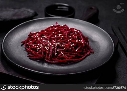 Tasty spicy Korean beet with spices and herbs on a dark concrete background. Asian food. Tasty spicy Korean beet with spices and herbs on a dark concrete background