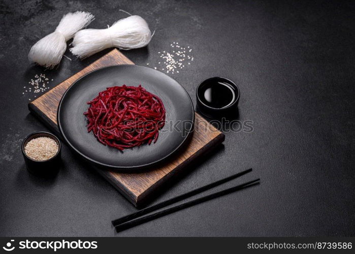 Tasty spicy Korean beet with spices and herbs on a dark concrete background. Asian food. Tasty spicy Korean beet with spices and herbs on a dark concrete background