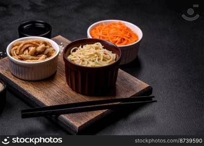 Tasty spicy Korean celery with spices and herbs on a dark concrete background. Asian food. Tasty spicy Korean celery with spices and herbs on a dark concrete background