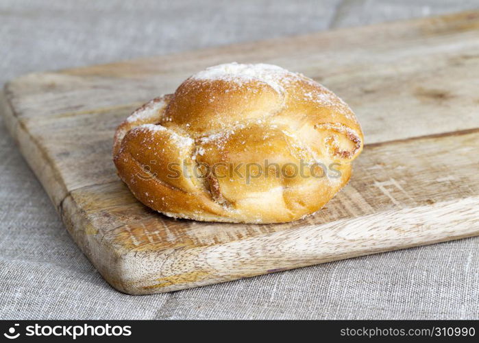 Tasty wheat bun lying on a wooden board on the chopping board, Simple kitchen. Tasty wheat bun