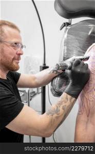 Tattoo artist making tattoo at the studio. High quality photography. Tattoo artist making tattoo at the studio
