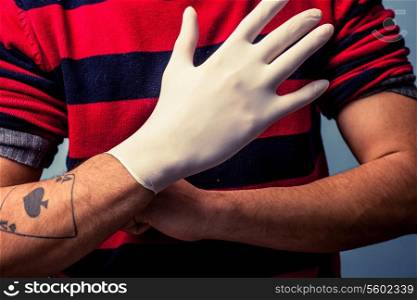 Tattoo artist putting on latex glove