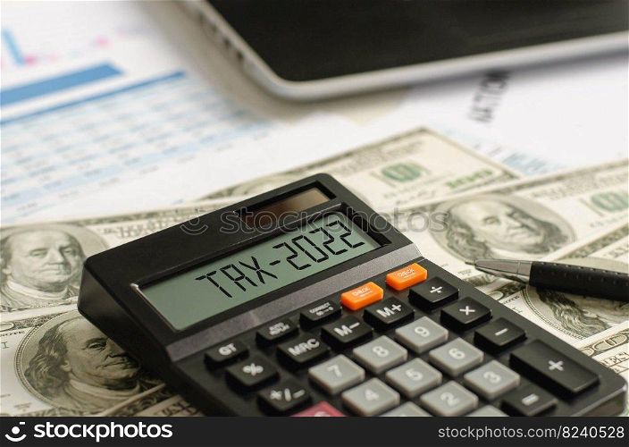 tax assistance with dollar-denominated banknotes On the display of the 2022 calculator, tax assistance, tax deductions are written.