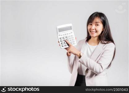Tax day concept. Woman confident smiling holding calculator and finger point device, Portrait excited happy Asian female studio shot isolated on white background, Account and finance counting income