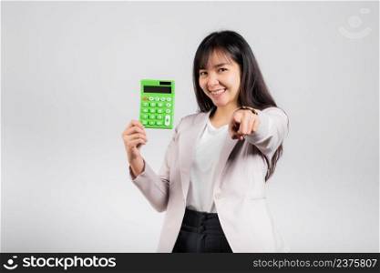 Tax day concept. Woman confident smiling holding calculator and finger point to camera, Portrait excited happy Asian female studio shot isolated on white background, It’s time to calculate your taxes