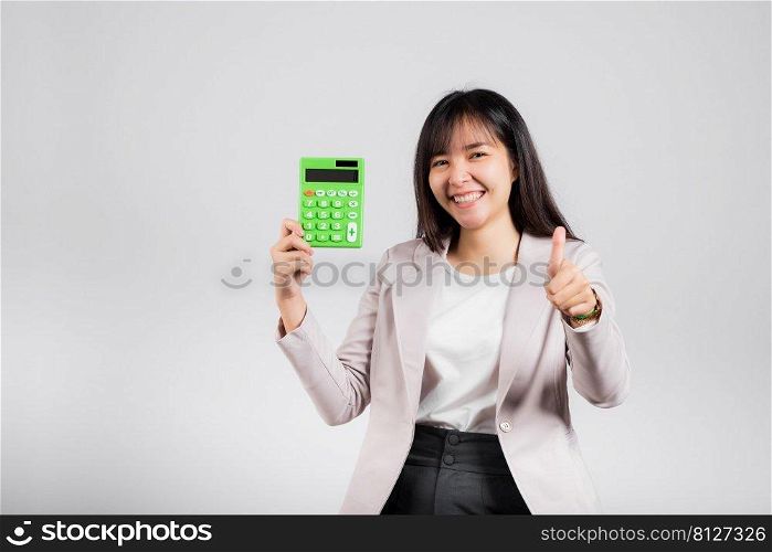 Tax day concept. Woman confident smiling holding electronic calculator and show thumb up for good gesture, excited happy Asian female isolated on white background, Account and finance counting income