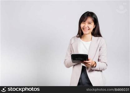 Tax day concept. Woman confident smiling holding electronic calculator, Portrait excited happy Asian young female studio shot isolated on white background, Business Account and finance counting income