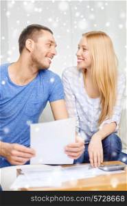 tax, finances, family, home and people concept - happy couple with papers and calculator talking at home