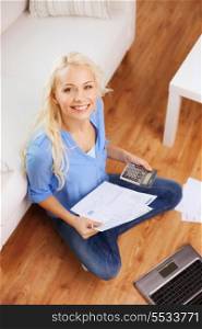 tax, finances, technology, home and happiness concept - smiling young woman with papers, laptop computer and calculator at home