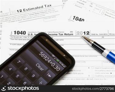 Tax form 1040 for tax year 2012 for US individual tax return with smartphone calculator