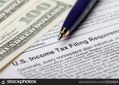 Tax form for nonresident with dollar bills and pen