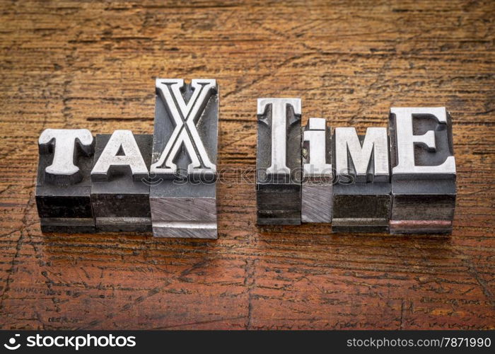 tax time - financial concept - words in mixed vintage metal type printing blocks over grunge wood