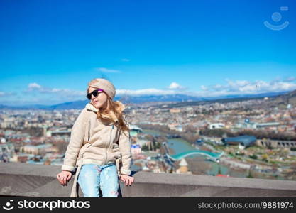 Tbilisi city panorama. Adorable kid with beautiful view of old city Tbilisi. Summer Cityscape.. Tbilisi city panorama. Old city, new Summer Rike park, river Kura, the European Square and the Bridge of Peace