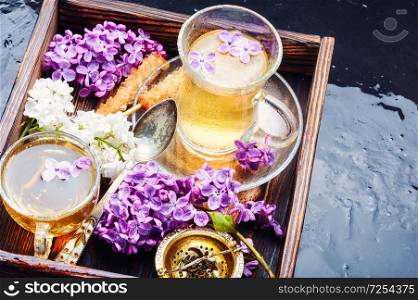 Tea and bouquet of beautiful spring flowers.Flower tea. Cup of tea and lilac flowers