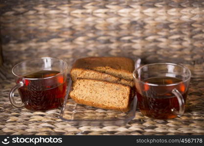 Tea and cake on wooden table in front of a wooden background